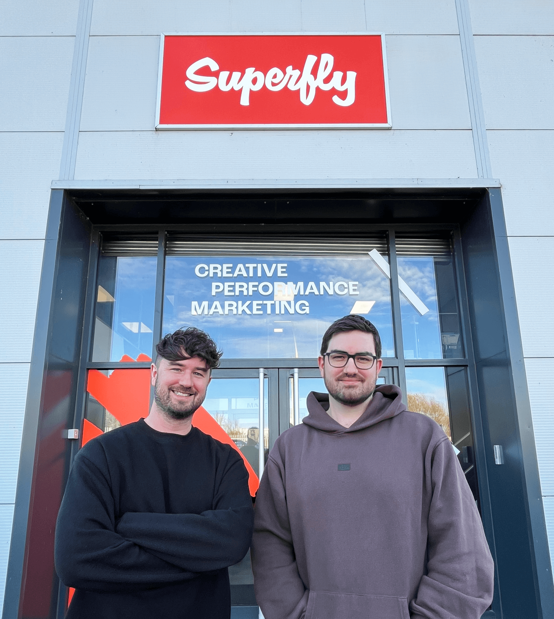 Directors and Founders Nick & Charlie Tyldsley stand outside the Brand-New Headquarters of Superfly Marketing, based in Melton. The wording on the office window reads "CREATIVE PERFORMANCE MARKETING".